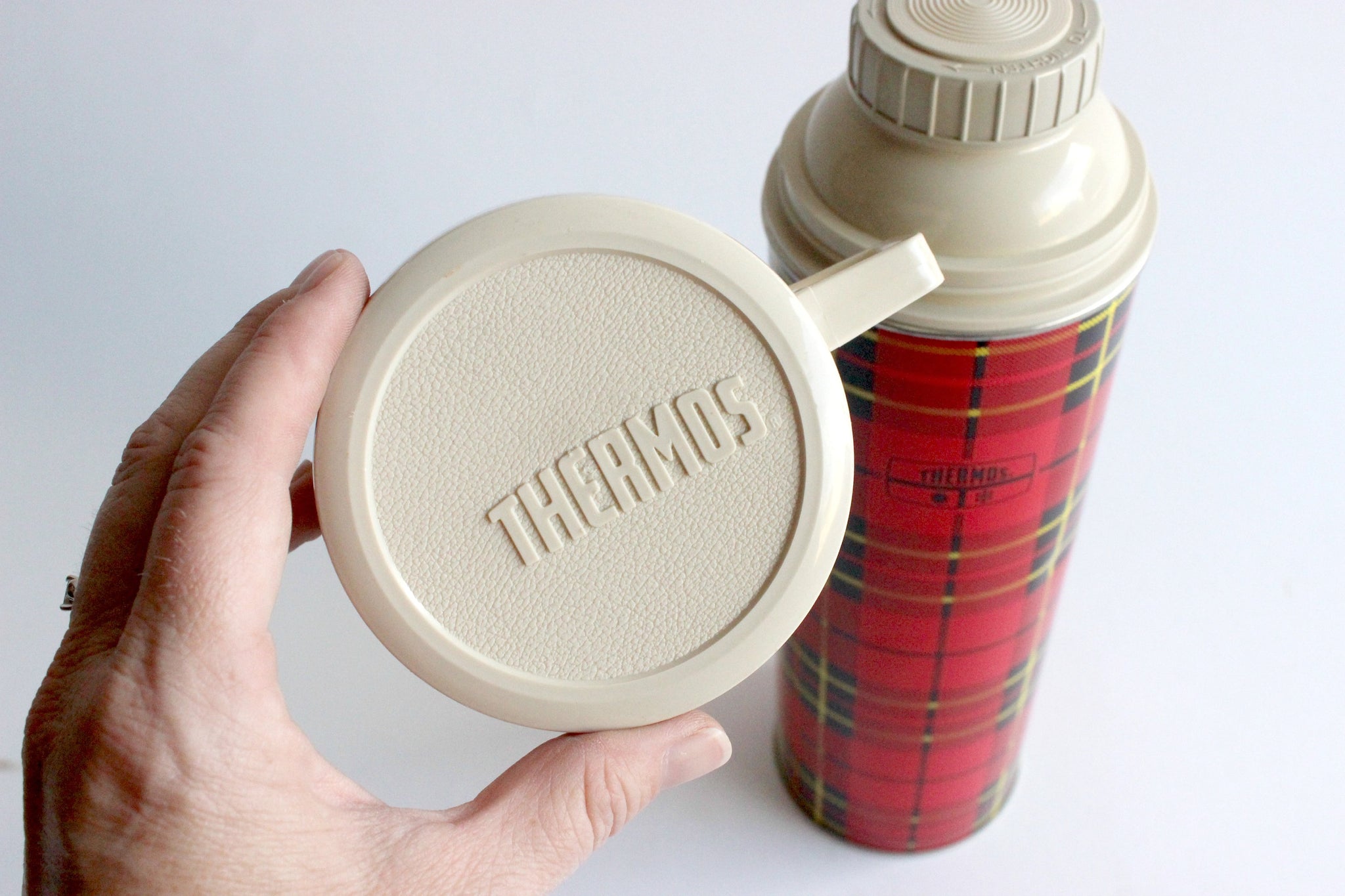 Vintage Thermos An Old Retro Plaid Thermos In The Hands Of A Child